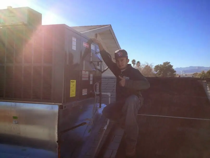 HVAC technician performing Heat Pump Repair on a rooftop unit in Crofton